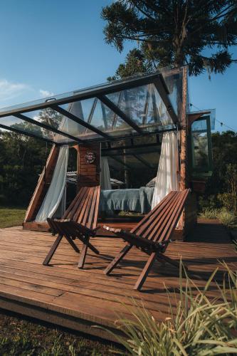 a couple of chairs sitting on a wooden deck at Morada do Guardião - Soldados Sebold in Barracão