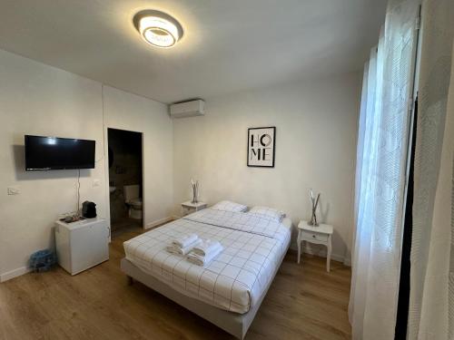 une chambre avec un lit et une télévision à écran plat dans l'établissement Le refuge du littoral n2, à Grimaud