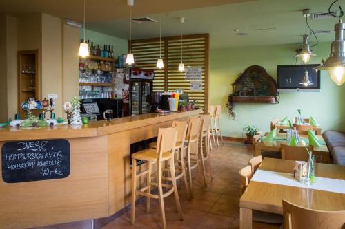 a restaurant with a bar and tables and chairs at Penzion U Zámecké Zahrady in Lipník nad Bečvou