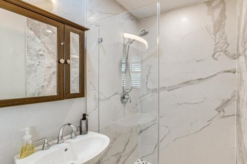 a white bathroom with a sink and a shower at Pet-Friendly Gem with Pool and Yard in West Palm Beach in West Palm Beach