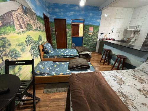 ein Zimmer mit zwei Betten und einem Gemälde an der Wand in der Unterkunft Casa Do Guh in São Thomé das Letras