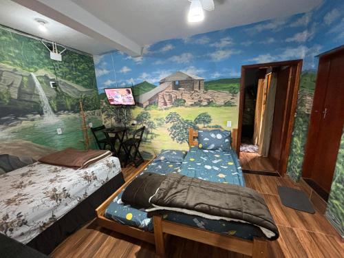 Zimmer mit 2 Betten und Wandgemälde in der Unterkunft Casa Do Guh in São Thomé das Letras