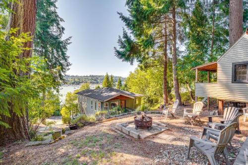 a home in the woods with a fire pit at Gig Harbor Home Large Deck, Outdoor Dining Area in Gig Harbor