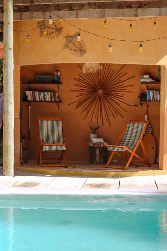 two chairs sitting next to a swimming pool at Mangará Pousada in Praia de Moitas