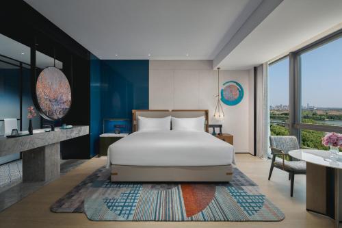 a bedroom with a bed and a table at Hotel Indigo Suzhou Jinji Lake by IHG in Suzhou