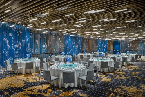 a banquet hall with tables and chairs and blue walls at Hotel Indigo Suzhou Jinji Lake by IHG in Suzhou