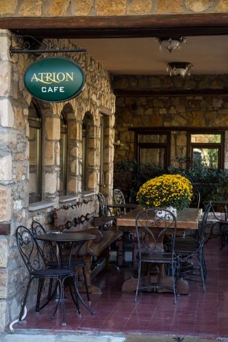 a restaurant with tables and chairs and a sign at Atrion Highland Hotel in Elatochori