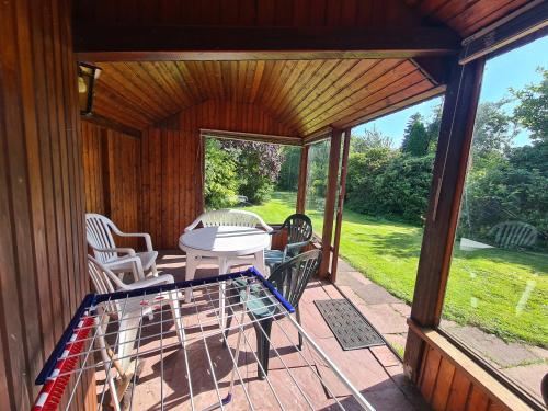 a screened in porch with a table and chairs at Schönes Ferienhaus, bis 6 Pers, zentral gelegen in Heide