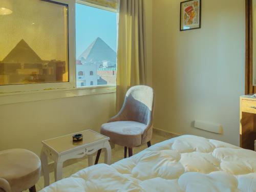 a bedroom with a bed and a chair and a window at pyramids rose view inn in Cairo