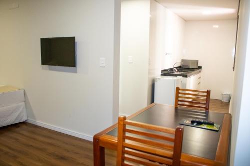 a room with a table and two chairs and a kitchen at Golden Ingá Hotel in Maringá