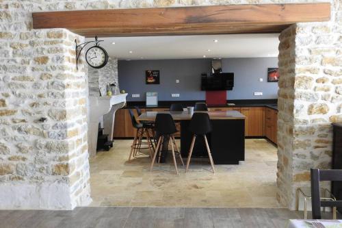 une cuisine et une salle à manger avec une table et des chaises dans l'établissement Magnifique corp de ferme rénové, à Changey