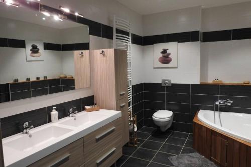 une salle de bain avec un lavabo, une baignoire et des toilettes dans l'établissement Magnifique corp de ferme rénové, à Changey