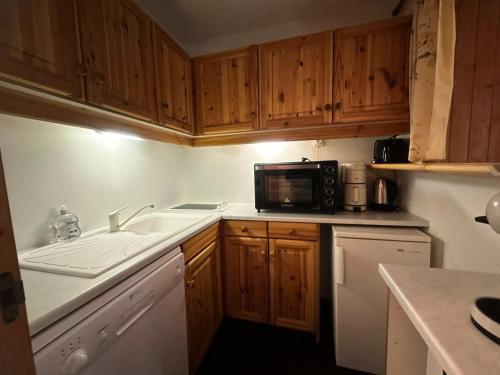 une cuisine avec un évier et un micro-ondes dans l'établissement Résidence Les Glaciers 3 - 2 Pièces pour 5 Personnes 204, à Aime La Plagne
