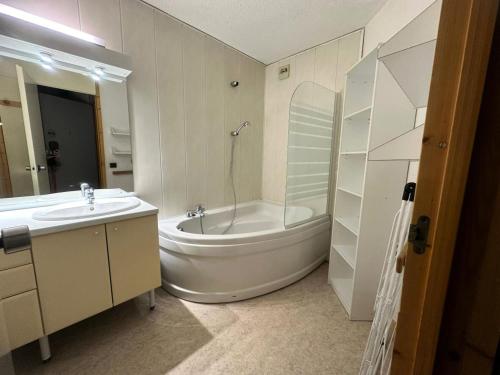 une salle de bain blanche avec une baignoire et un lavabo dans l'établissement Résidence Les Glaciers 3 - 2 Pièces pour 5 Personnes 204, à Aime La Plagne