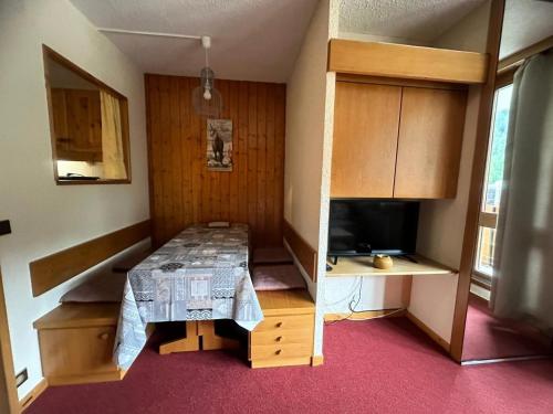 Cette petite chambre dispose d'une table et d'une télévision. dans l'établissement Résidence Les Glaciers 3 - 2 Pièces pour 5 Personnes 204, à Aime La Plagne