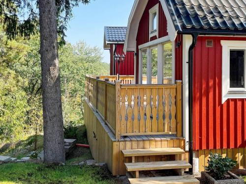 a red house with a wooden staircase leading to a porch at 4 person holiday home in HUDDINGE-By Traum in Huddinge