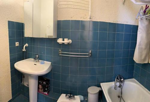 La salle de bains est pourvue de carrelage bleu, d'un lavabo et de toilettes. dans l'établissement Résidence Christiana - Super appartement au Centre de la Station MAE-9701, à Vars