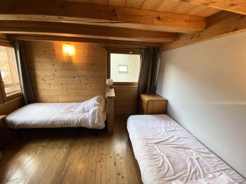une chambre avec deux lits dans une cabane en rondins dans l'établissement Résidence Melezet 1 - Superbe duplex T2 à 100m des pistes secteur point show MAE-9811, à Vars
