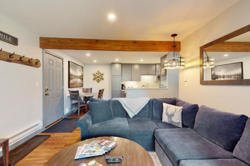 een woonkamer met een blauwe bank en een tafel bij Beaver Creek Bungalow in Avon