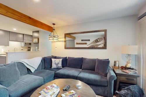 a living room with a blue couch and a table at Beaver Creek Bungalow in Avon