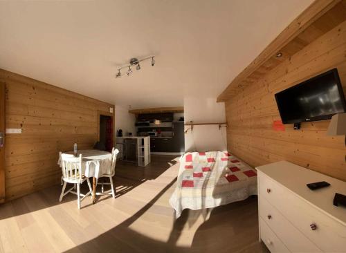 - un salon doté d'une table et d'une télévision dans l'établissement Résidence Gaubert - Coquet studio 2 couchages à Vars près du point show MAE-9841, à Vars