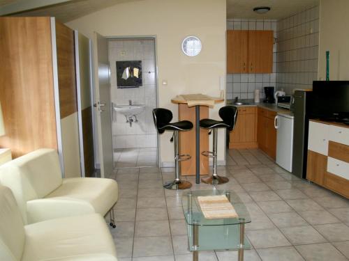 - une cuisine avec un canapé, des chaises et un évier dans l'établissement Pension Prell, à Düren