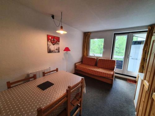 Cette chambre comprend une table, un canapé et une fenêtre. dans l'établissement Résidence Eyssina - Appartement 100m des pistes à Vars de 6 couchages MAE-9941, à Vars