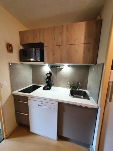 une petite cuisine avec un évier et un micro-ondes dans l'établissement Résidence Eyssina - Appartement 100m des pistes à Vars de 6 couchages MAE-9941, à Vars