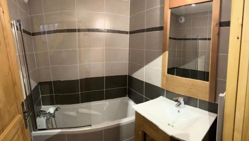une salle de bain avec un lavabo et une baignoire dans l'établissement Chalet Des Rennes - Super duplex résidence de standing au pied des pistes MAE-9951, à Vars