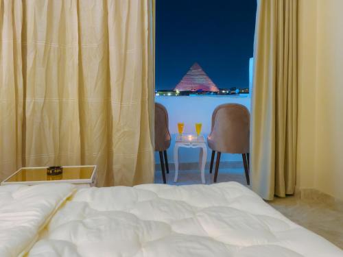 a bedroom with a bed and a table with two chairs at pyramids rose view inn in Cairo