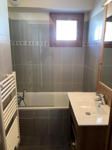 une salle de bain avec un lavabo, une baignoire et un miroir dans l'établissement Chalet Des Rennes - Appart tout confort plein sud dans résidence de standing & garage au pied des pistes MAE-0001, à Vars