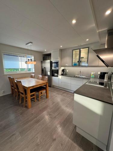 a kitchen and dining room with a table and chairs at Selveier leilighet, Parkering med El-bil ladder in Florø