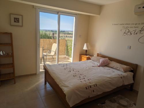 a bedroom with a bed and a large window at Kiti 2 bedroom Penthouse in Kiti
