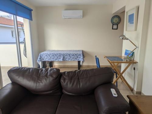 een woonkamer met een leren bank en een tafel bij Kiti 2 bedroom Penthouse in Kiti