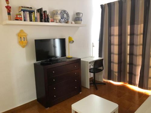 a living room with a television on a dresser at Apartamento Lucía Garden City con piscina climatizada in Playa Fañabe