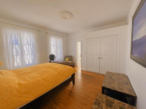 a bedroom with a large bed with a yellow bedspread at WHITE SWAN House in Niagara Falls