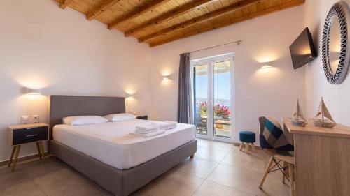 a bedroom with a bed and a desk and a window at Themonia Studios Kimolos in Kimolos