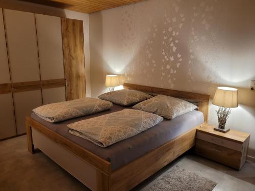 a bedroom with a bed with two pillows on it at Komfort-Ferienwohnung Auf der Eulenburg in Grafengehaig
