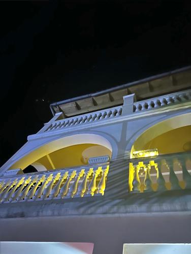 a white building with yellow lights on the side of it at Guest House Pulake in Berat
