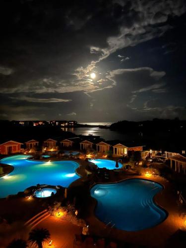 a view of a resort at night with a full moon at Sanctuary at Redfish 2115 by Newman-Dailey in Santa Rosa Beach