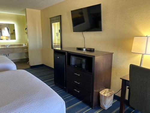 a hotel room with a bed and a flat screen tv at Days Inn by Wyndham Holbrook in Holbrook