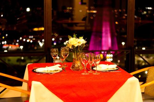 a table with wine glasses and a vase of flowers at Golden Ingá Hotel in Maringá