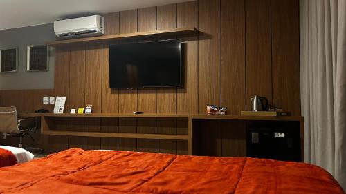 a hotel room with a television and a bed at Jade Hotel Brasília in Brasilia