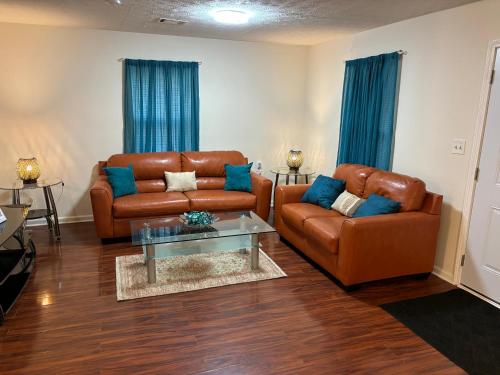 a living room with two leather couches and a table at Atlanta Quiet Private Room 2 in Atlanta
