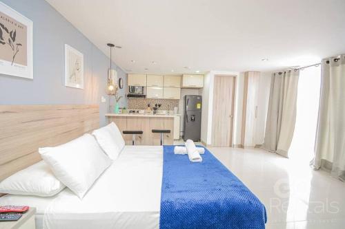 a bedroom with a large bed with a blue blanket at Charming Decor & Stunning Views Green Poblado in Medellín
