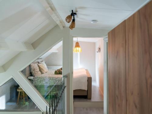 a staircase leading to a bedroom with a bed at Cozy Villa w Sauna and BBQ in Hattemerbroek