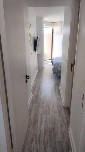 a hallway with a room with a bed and a wooden floor at San Alfonso del Mar Ideal in Mirasol