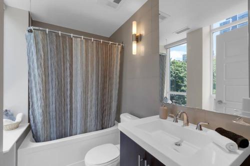a bathroom with a sink and a toilet and a window at 1560 sqft Elegant Condo at Downtown Hi-End Shopping & Dining Area - CN Tower View, Bidet, LockBox in Toronto