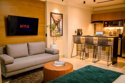 a living room with a couch and a kitchen at Flat Praia Luxury Century in Vitória