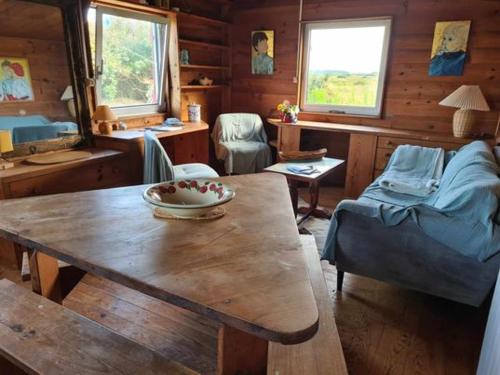 a living room with a wooden table in a cabin at Le Terrier sur la dune de Tronoën in Le Stang